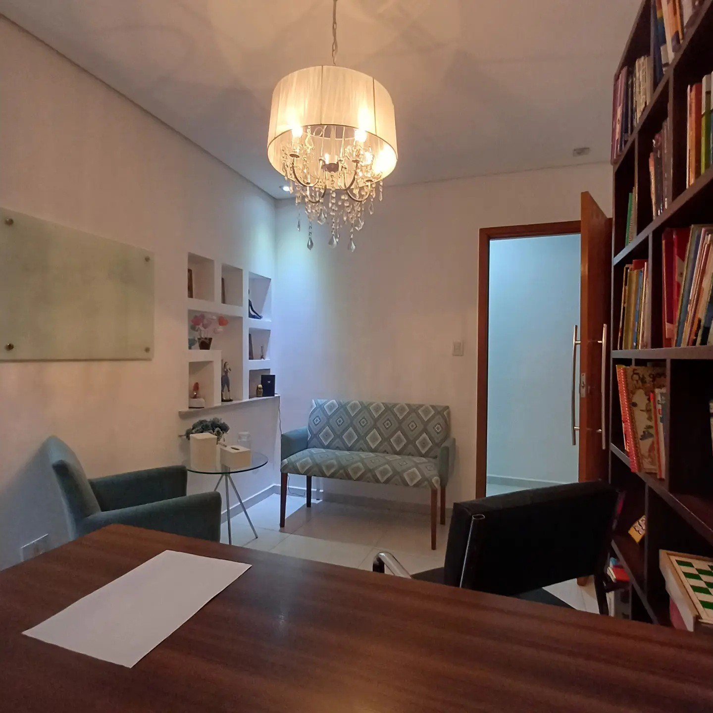 Sala de atendimento com mesa e poltronas